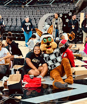 The San Antonio Spurs' Coyote poses for a photo with one of the girls from S.J. Davis Middle School following the team's gift-opening at Frost Bank Center.